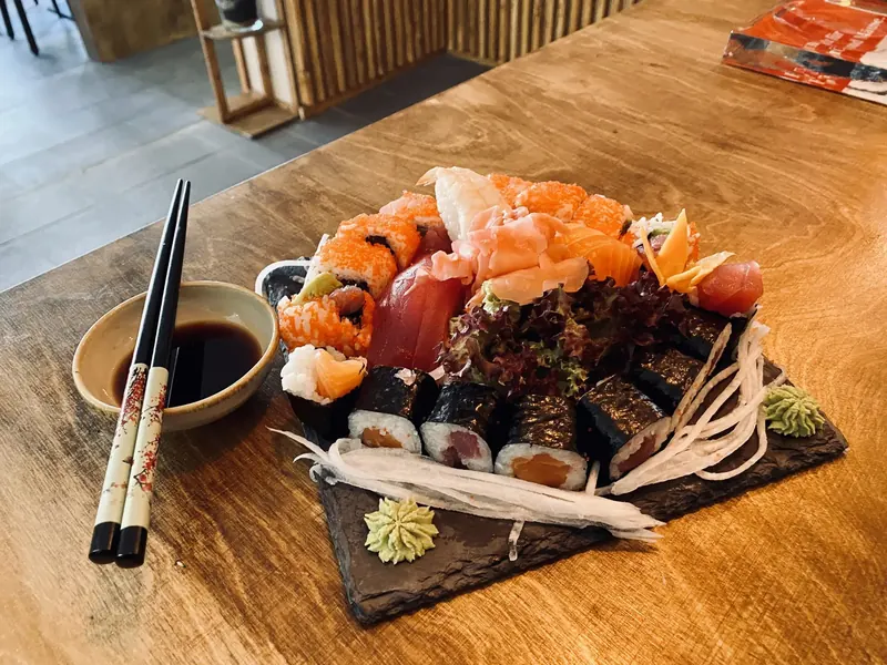Sashimi und Maki mit Sojasauce und Stäbchen